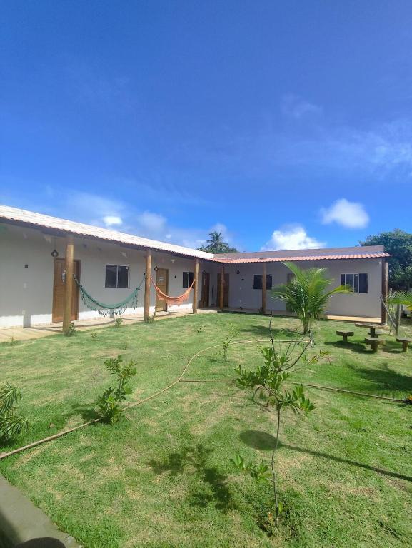 a building with a hammock in the yard at Charmoso Village no Povoado de Coqueiros in Jandaíra