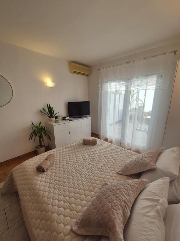 a bedroom with a large bed with pillows on it at Studio Apartman Bubi in Nečujam