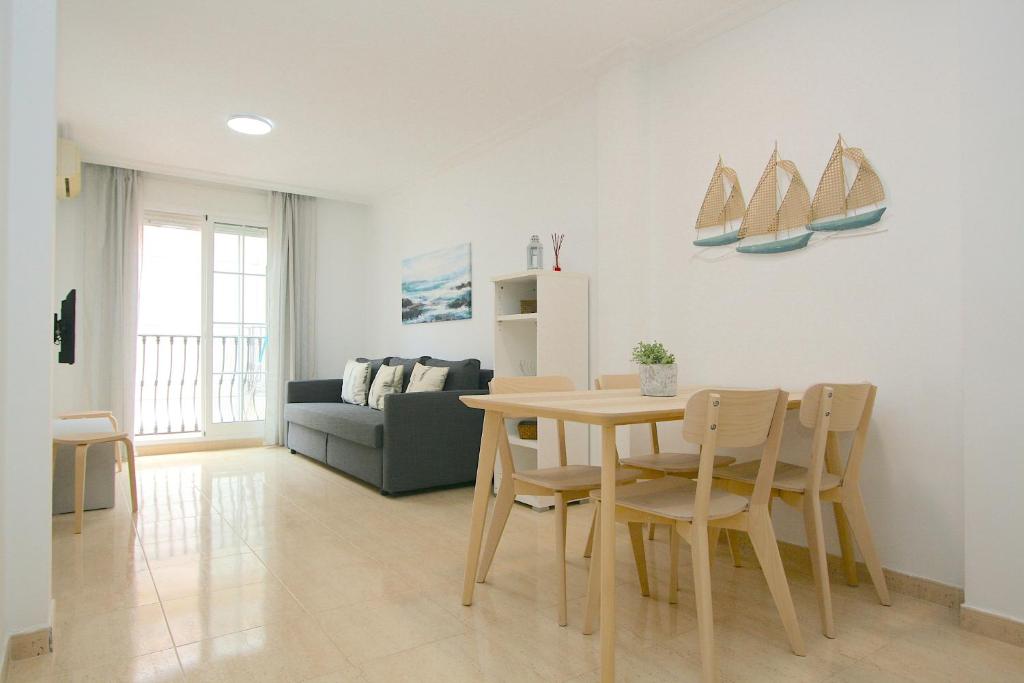 a living room with a table and chairs and a couch at Apartamento Jazmín in Fuengirola