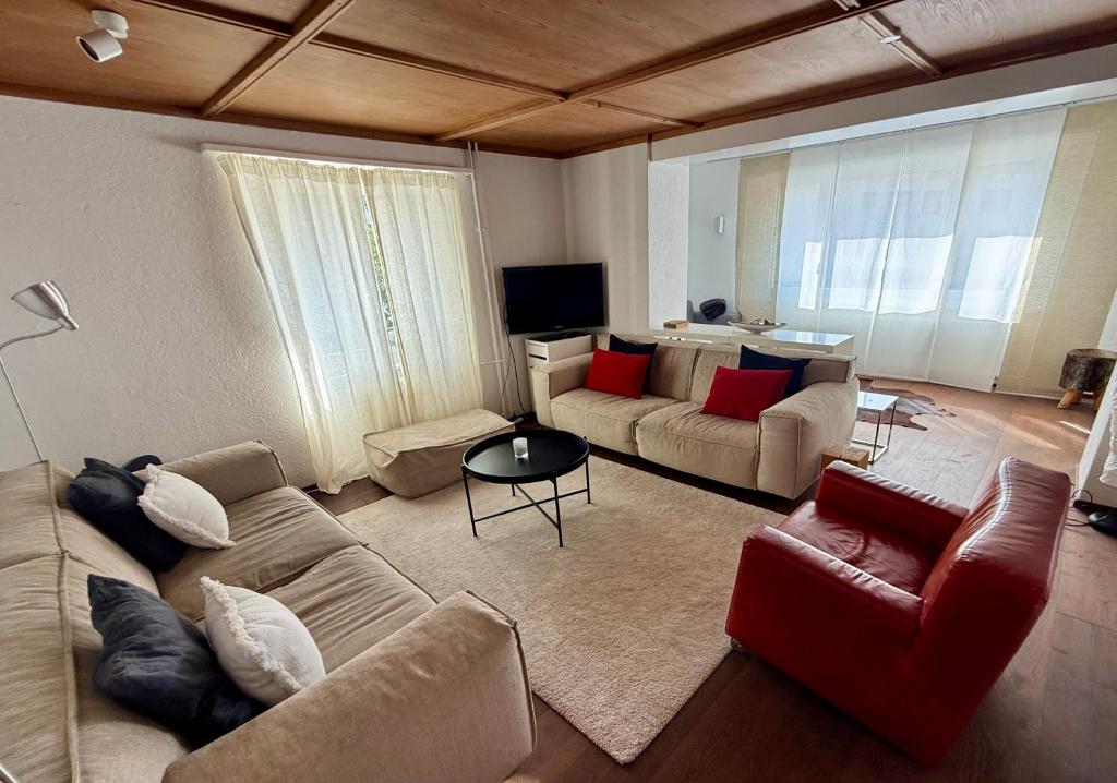 a living room with two couches and a television at Family Laax Apt Lakeside Mountain Views in Laax
