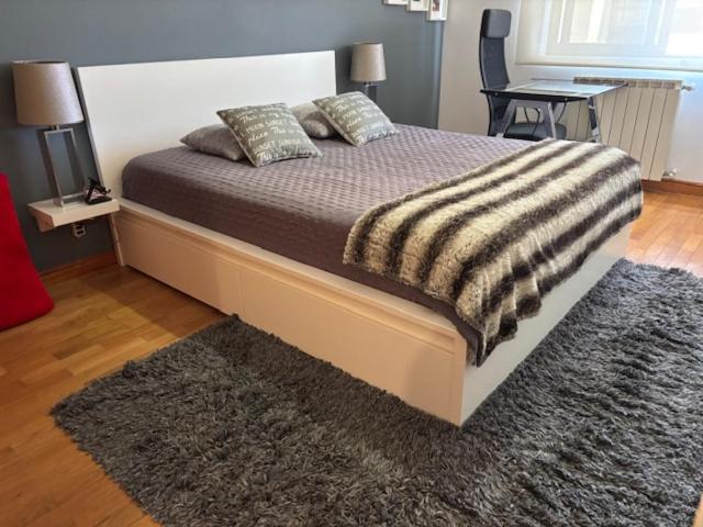 una camera da letto con un grande letto con un tappeto di Guia Cascais Room Suite Opportunity a Cascais