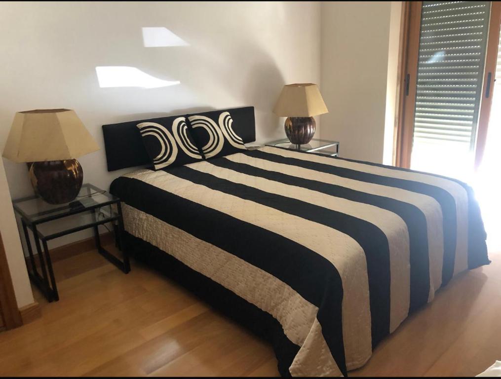 カスカイスにあるGuia Cascais Room Suite Opportunityのベッドルーム1室(大型ベッド1台、ランプ2つ付)