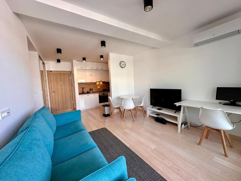 a living room with a blue couch and a table at River side 18 in Herceg-Novi
