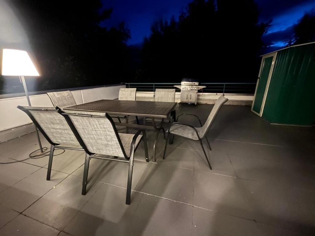 a table and chairs on a patio at night at App 624 Panoramic Hohegeiß Terrassenhaus in Braunlage