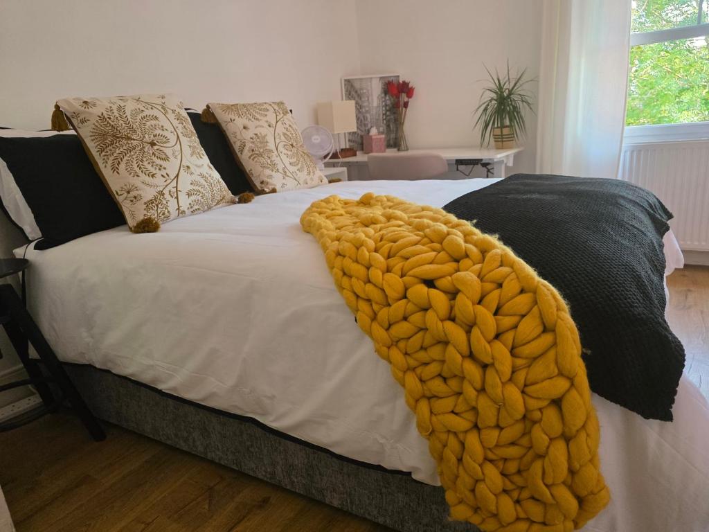 a bed with a blanket on top of it at Walk to Wembley Stadium and Arena 2 Bedroom Sleeps 4 in London