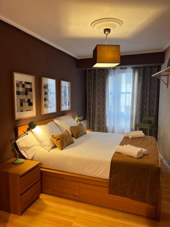 a bedroom with a large bed with white sheets at Vivienda Sol in Ferrol
