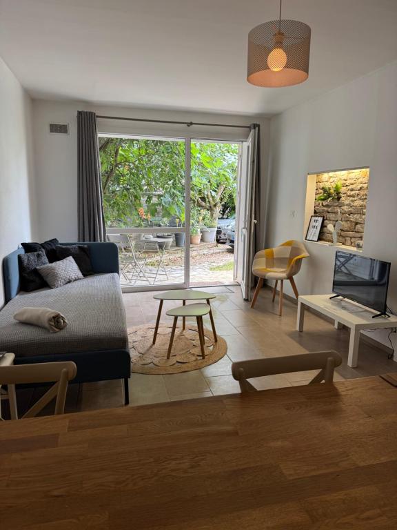 una sala de estar con un sofá y una mesa en La Villa Bis, en Vesoul