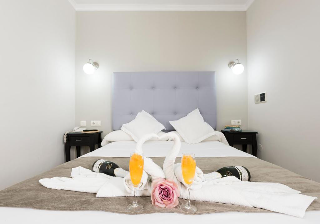 a hotel room with a bed with towels and two cocktails at Hotel Toboso Chaparil in Nerja