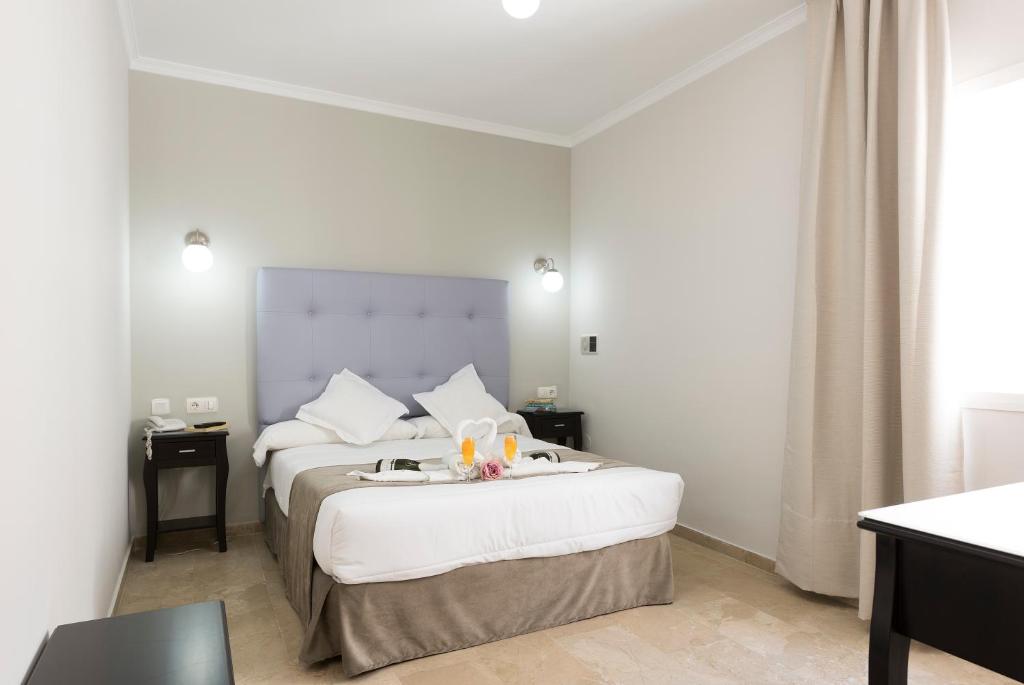 a hotel room with a bed with a tray on it at Hotel Toboso Chaparil in Nerja