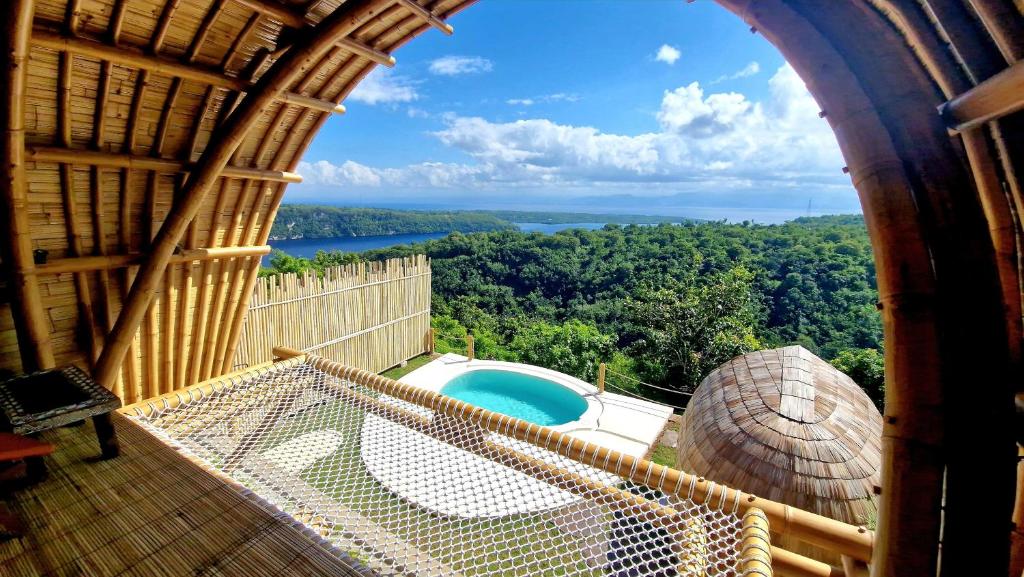 a balcony with a view of a swimming pool at Marilea Bamboo Villas Concept , Private pool, seaview, Adults only in Nusa Penida