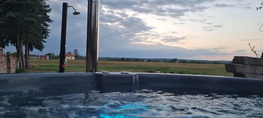a hot tub with a view of a field at Wygwizdowo in Stare Kurowo