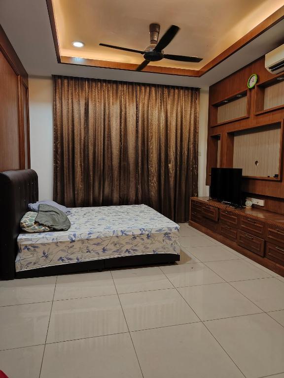 a bedroom with a bed and a flat screen tv at Dcarlton seaview apartment in Masai