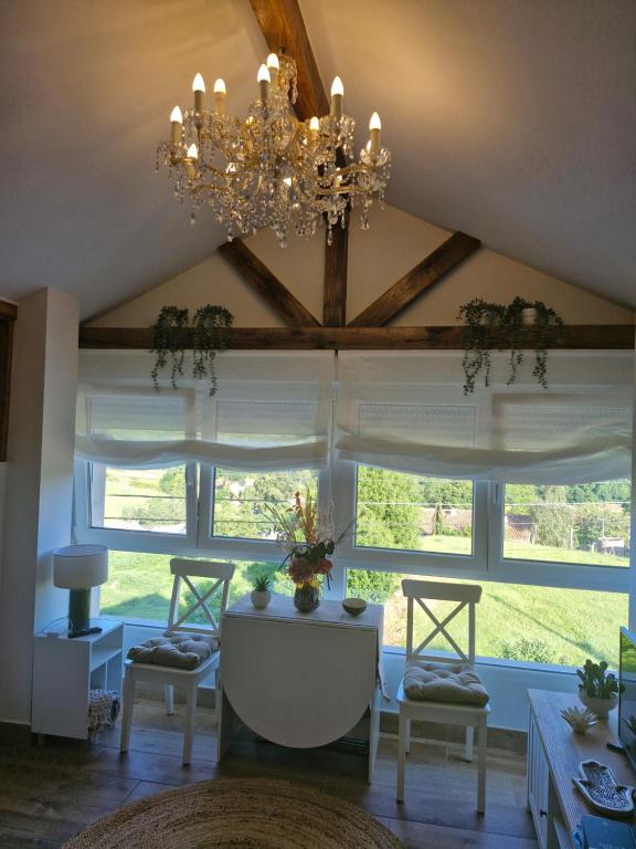 a living room with a chandelier and large windows at "La casuca de Finu" #2# Santillana del Mar in Santillana del Mar