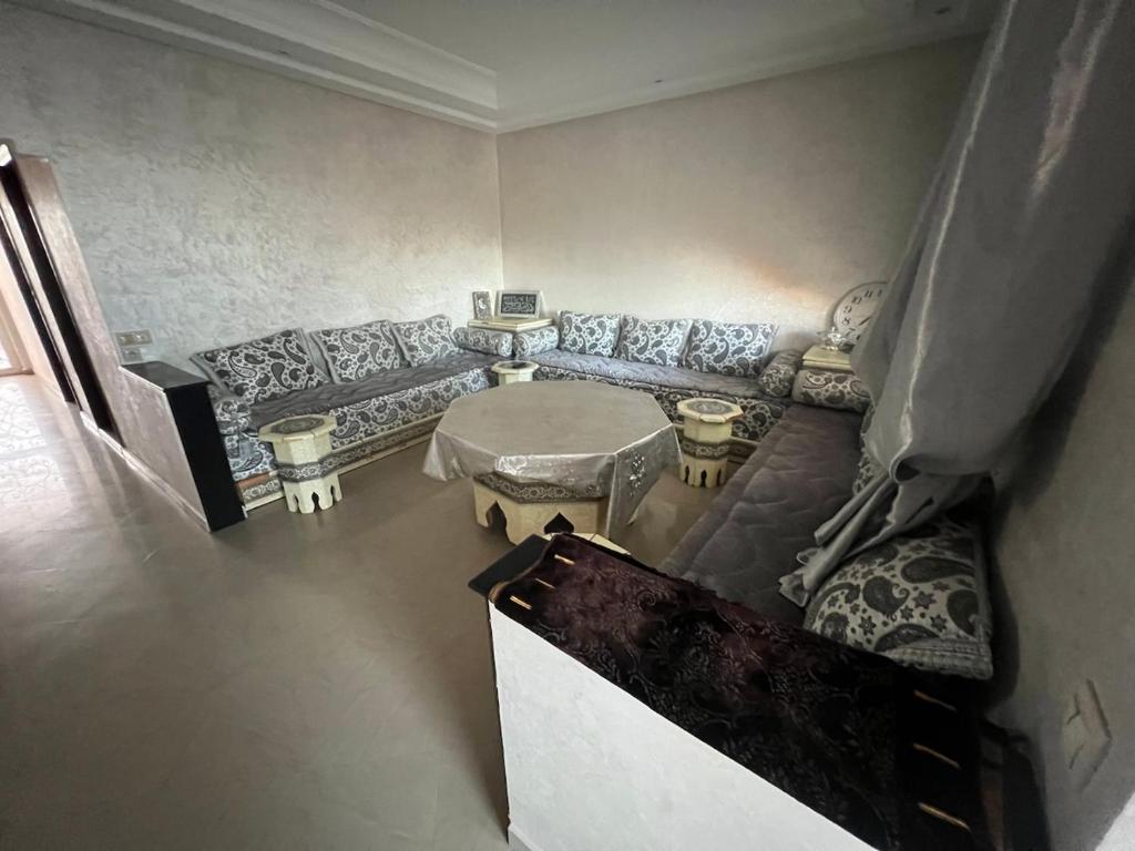 a living room with a couch and a table at Villa Jacuzzi à 200m de la plage Tamaris in Dar Bouazza