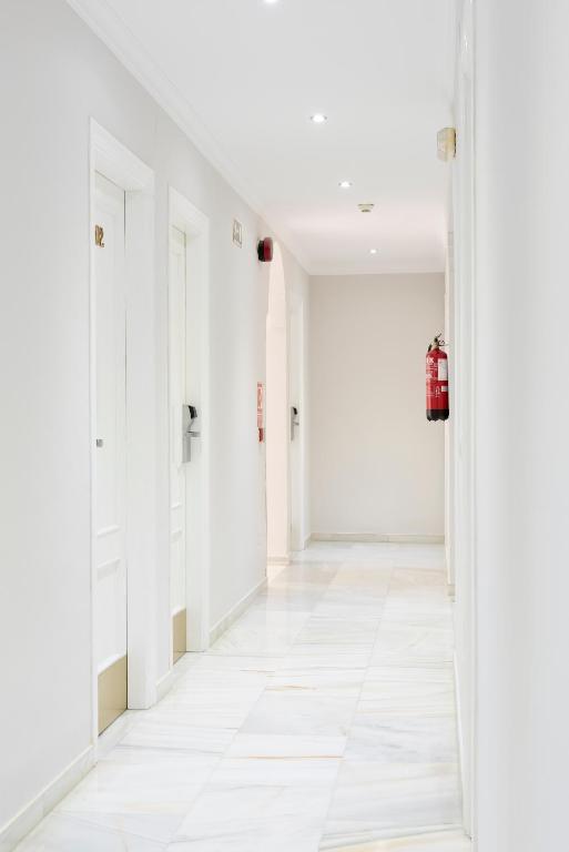 an empty hallway with white walls and white floors at Hotel Toboso Chaparil in Nerja