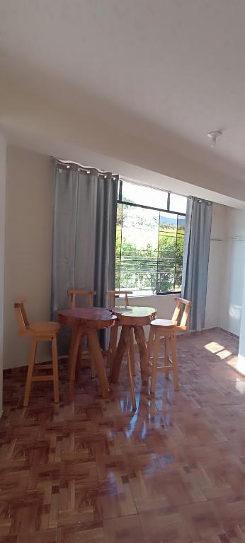a room with two tables and chairs and a window at Hospedaje Dase in Oxapampa