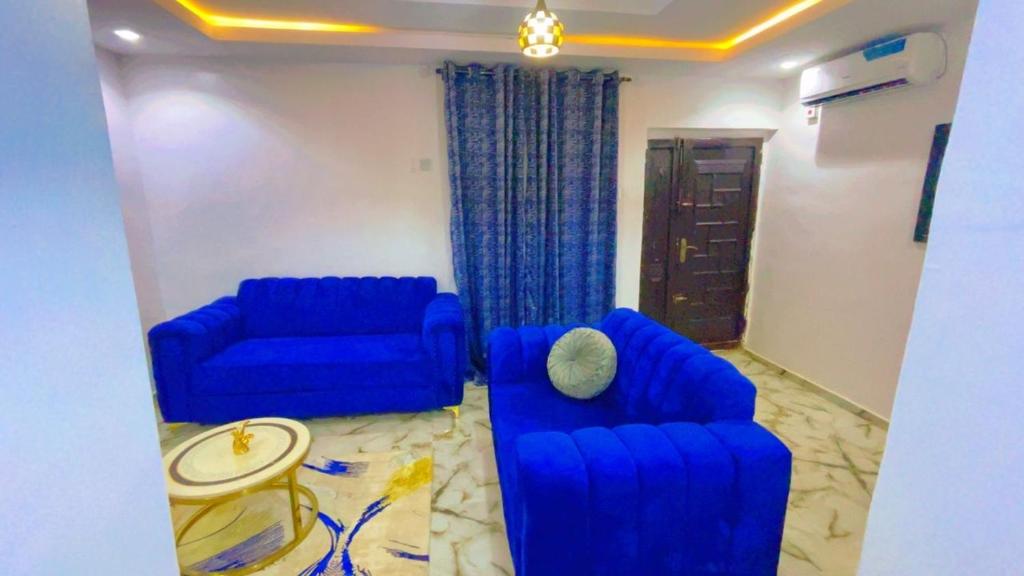 a living room with two blue couches and a table at TemiHOUSE40 in Ibadan