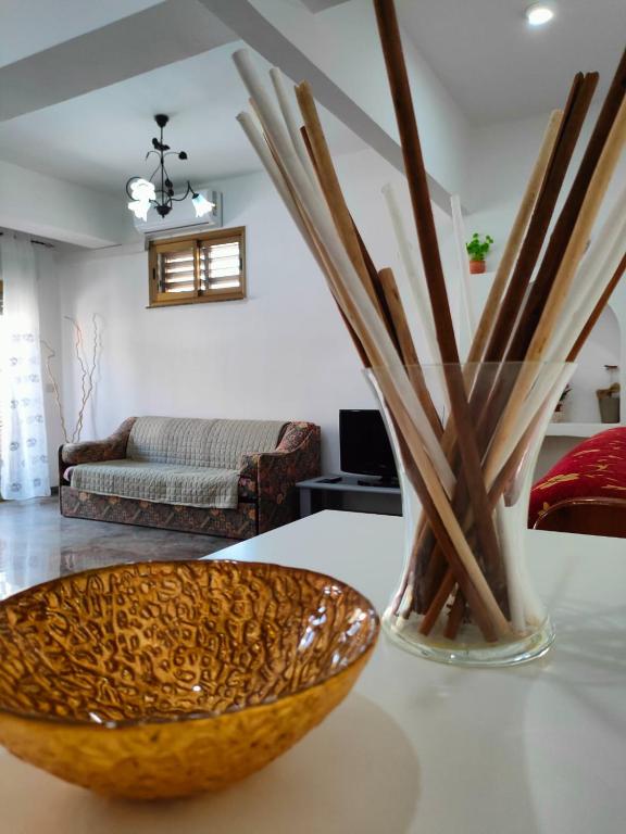 a living room with a vase with wooden sticks in it at Casa Vacanze A Due Passi Dal Mare in Furci Siculo