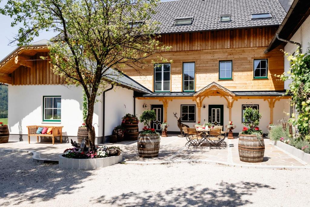 ein Haus mit einem Innenhof mit einem Baum und Stühlen in der Unterkunft Lippingergut - "Sissis Sommerfrische" in St. Wolfgang