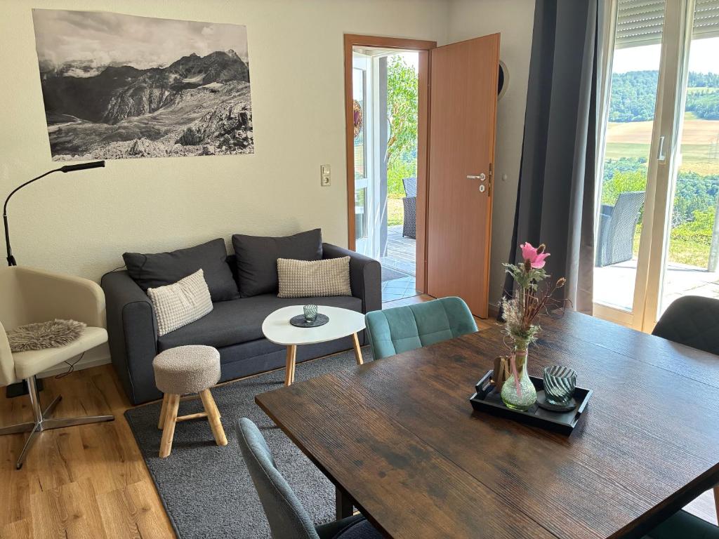 a living room with a couch and a table at FeWo Silence&View in Weilheim