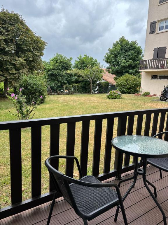 une table et des chaises sur une terrasse avec une cour dans l'établissement CAPUCINES - T2 ANGLET avec stationnement, à Anglet