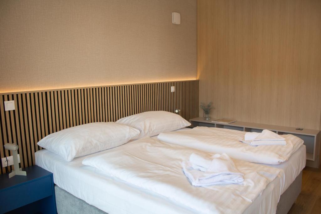 two beds in a room with towels on them at Hotel Taxis Bratislava - Suites in Bratislava
