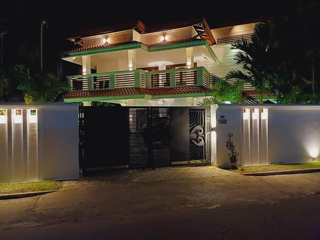 a house with a gate and a fence at night at JarushanInnHotel in Jaffna