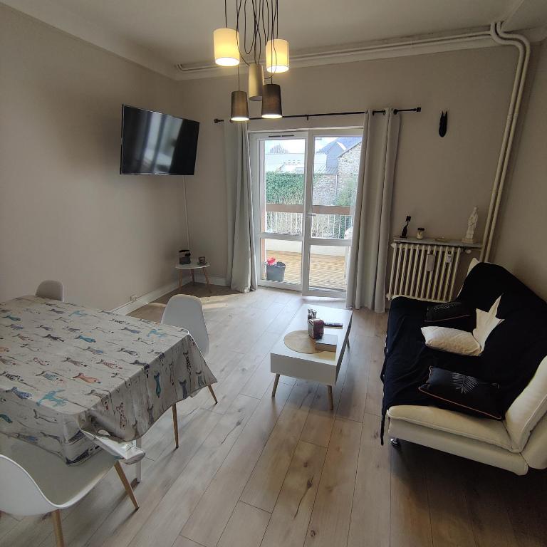 une chambre avec un lit et un salon avec un canapé dans l'établissement Appartement T2 avec terrasse Luchon, à Luchon