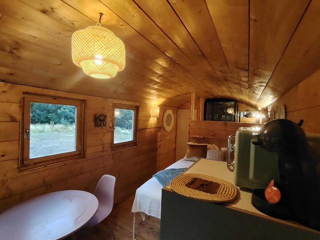 a room with a bed and a table in a tiny house at Le refuge cévenol in Concoules