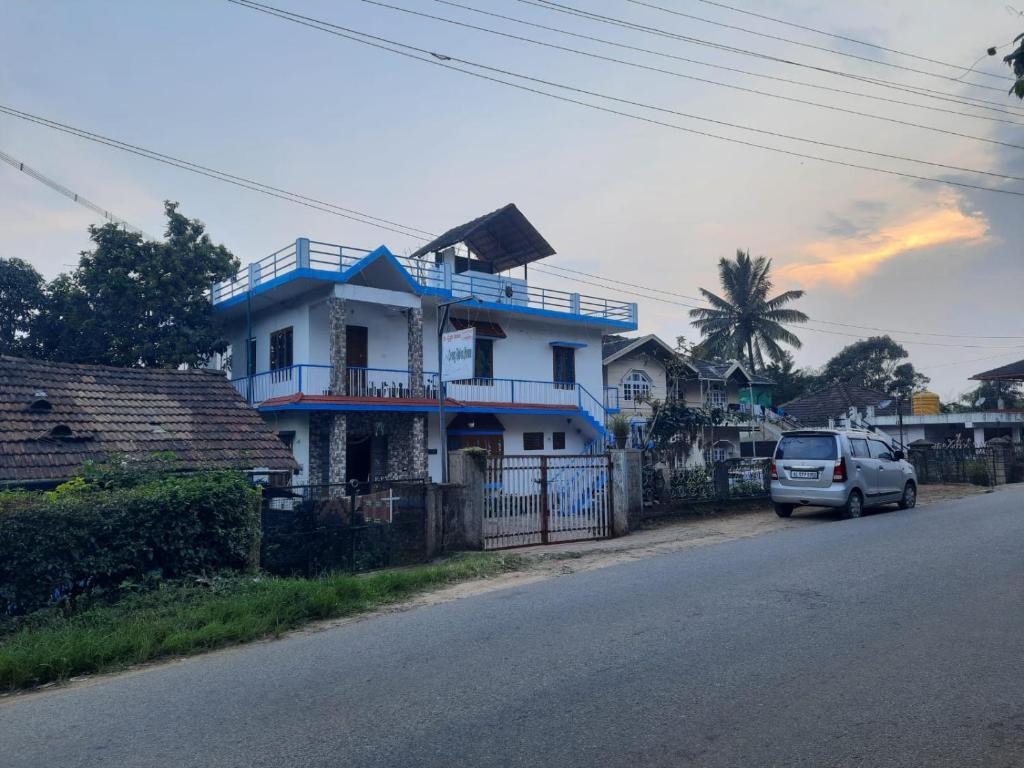 Un coche aparcado delante de una casa en una calle en Coorg Relax Home, en Madikeri