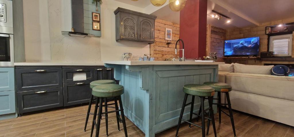 a kitchen with a bar with stools and a couch at Katerina Boutique Apartment in Bansko