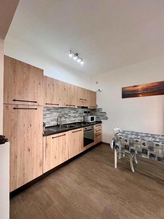 a kitchen with wooden cabinets and a sink and a table at Chicco & Didi in Rapallo