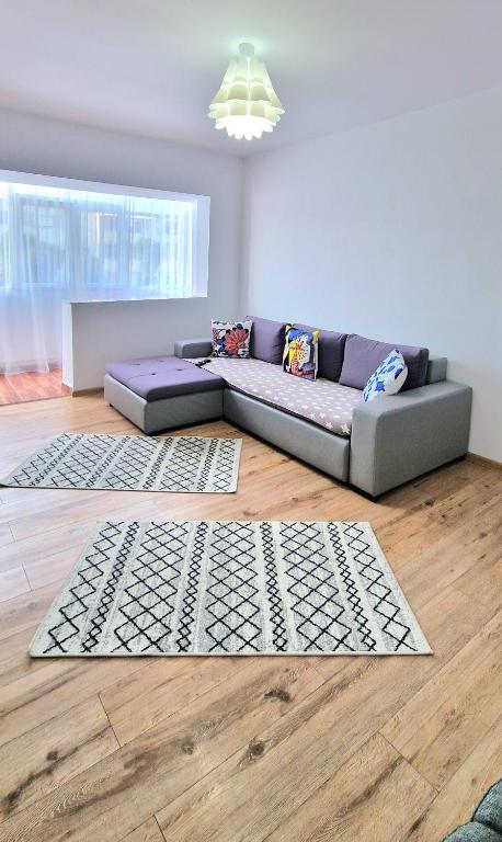 a living room with a couch on a wooden floor at Apartament Niki in Mangalia
