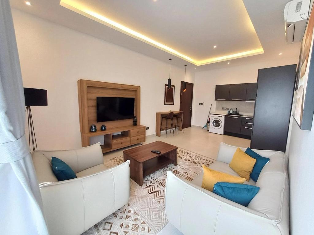 a living room with two white couches and a table at Modern 1-Bedroom Apartment in Cantonments in Accra