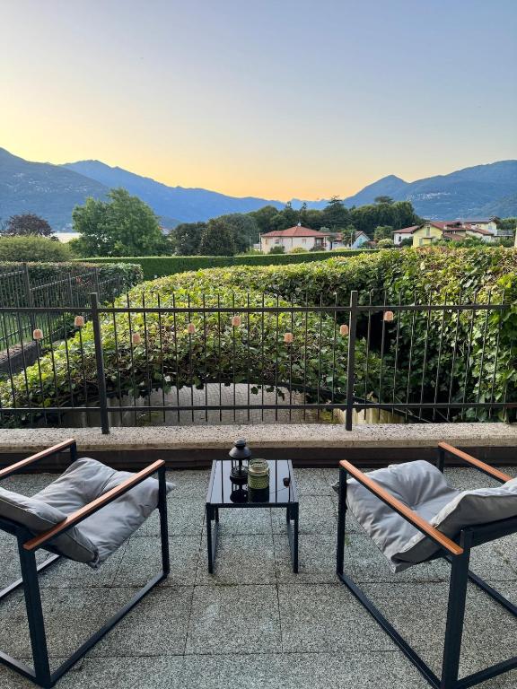 two chairs and a table with a view of a vineyard at Casa Lagobello, Piscina e Relax sul Lago Maggiore in Germignaga