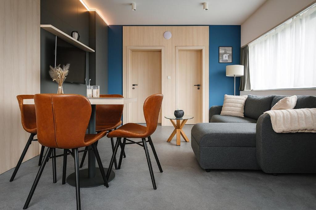 a living room with a couch and a table and chairs at A2 Apartment & Studio in Ružomberok