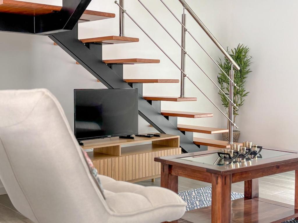 a living room with a table and a staircase at Casa Norbina in Ribeira Quente