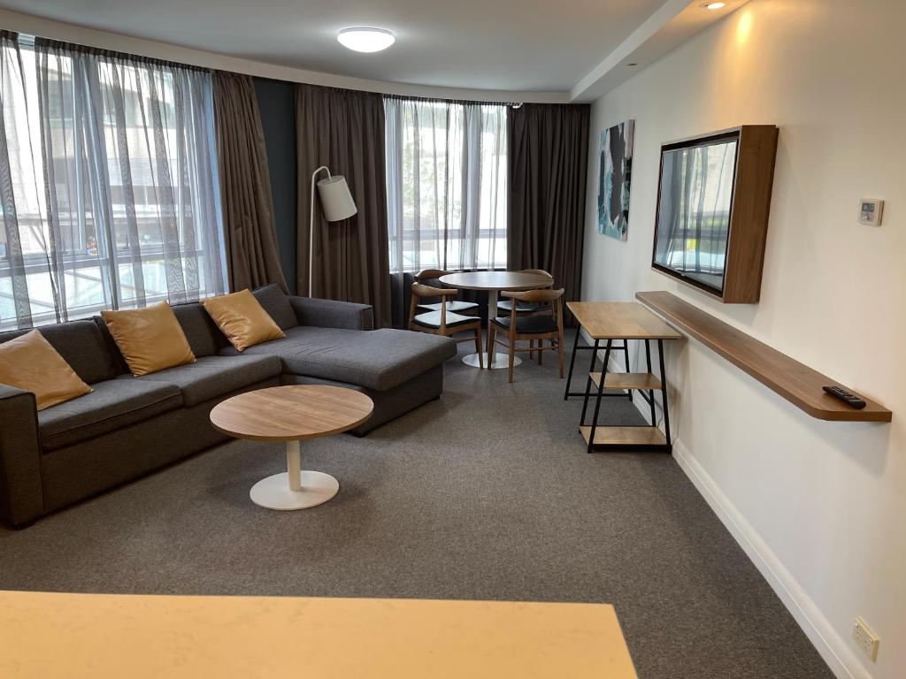 a living room with a couch and a table at Spacious One-Bedroom or Studio with Balcony in Sydney
