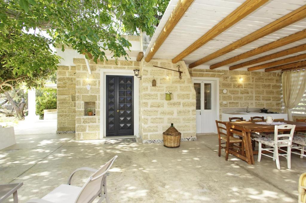 un patio extérieur avec une table et des chaises en bois dans l'établissement Dimora Maniva, à Parabita