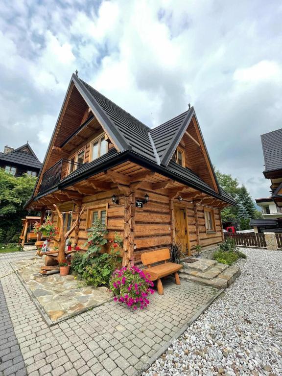 a log cabin with a bench in front of it at Chata Aleksandra in Zakopane