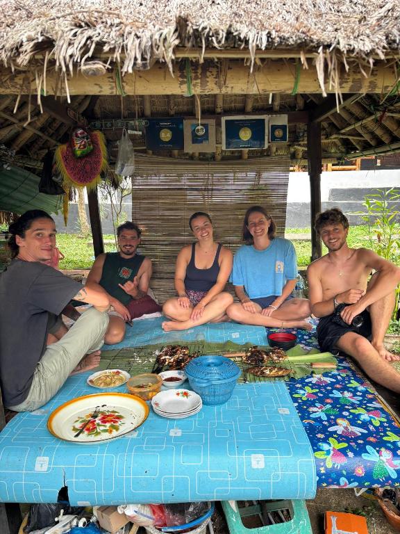 龙目岛库塔Perwita Homestay的一群人围坐在桌旁吃饭