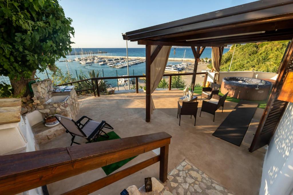 a patio with chairs and a hot tub and the ocean at Baia Marina Suite with private jacuzzi in Balestrate