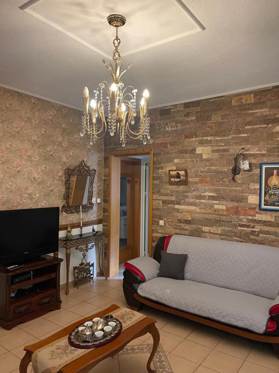 a living room with a couch and a chandelier at Korca Center Apartment in Korçë