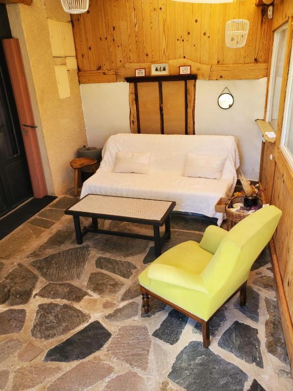 - une chambre avec un lit et une chaise jaune dans l'établissement Studio au cœur de Laguiole, à Laguiole
