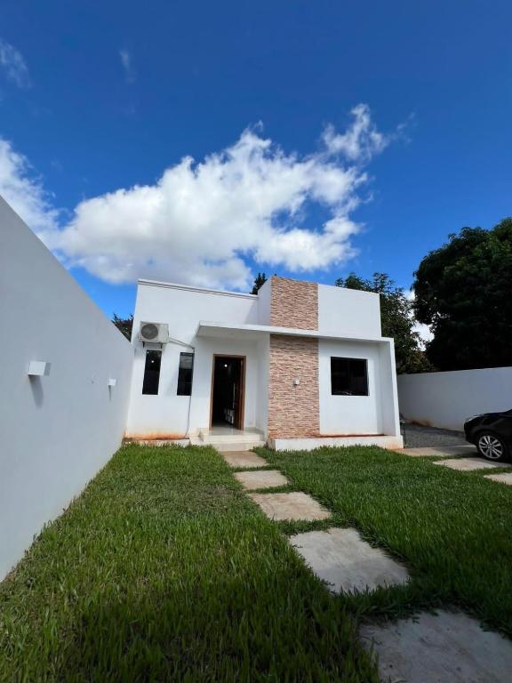 a white house with a grass yard at Casa de 2 habitaciones y 4 camas in Barrio San Isidro (2)