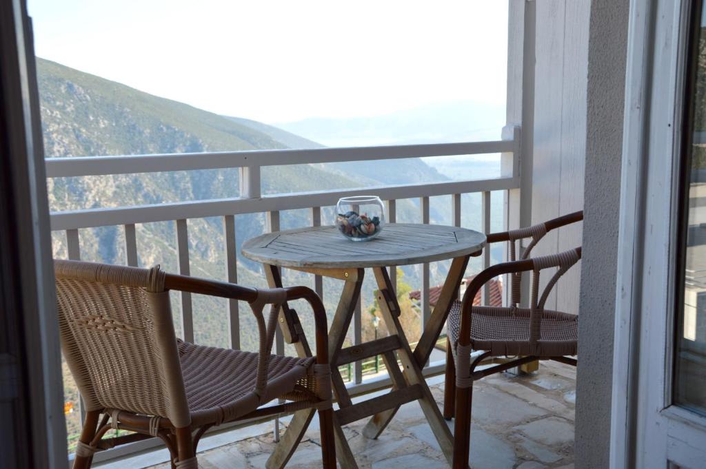 a table and chairs on a balcony with a glass of wine at Art Pythia Boutique in Delphi