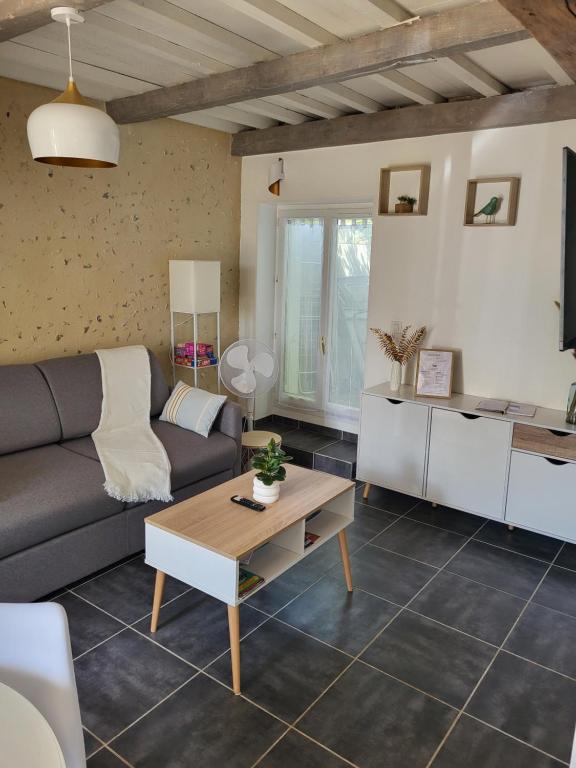 a living room with a couch and a table at Jolie maison cosy en sologne in Romorantin
