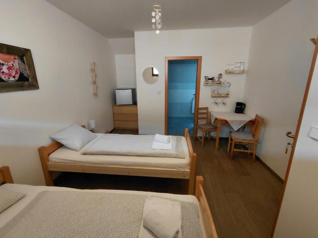 a room with two beds and a table with a dining room at Pivní lednice in Lhota pod Libčany