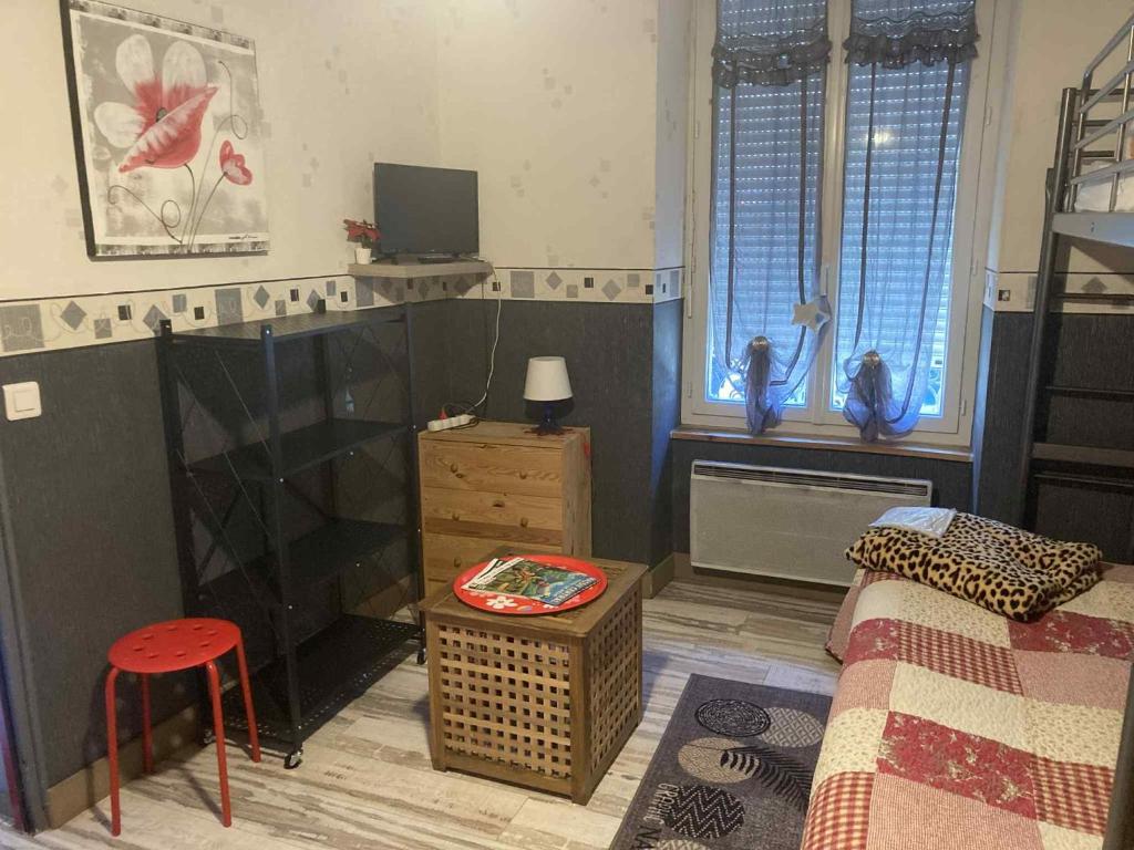 a bedroom with a bed and a tv and a stool at Studio MARMOTTES au RDC a HYPER centre du Mont DORE in Mont-Dore