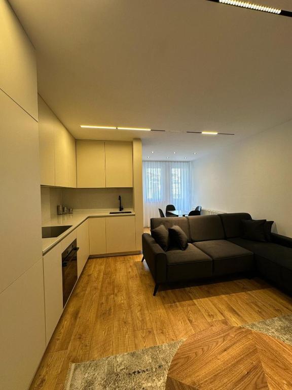 a living room with a couch and a kitchen at Pristina Luxury Apartments 24 in Pristina